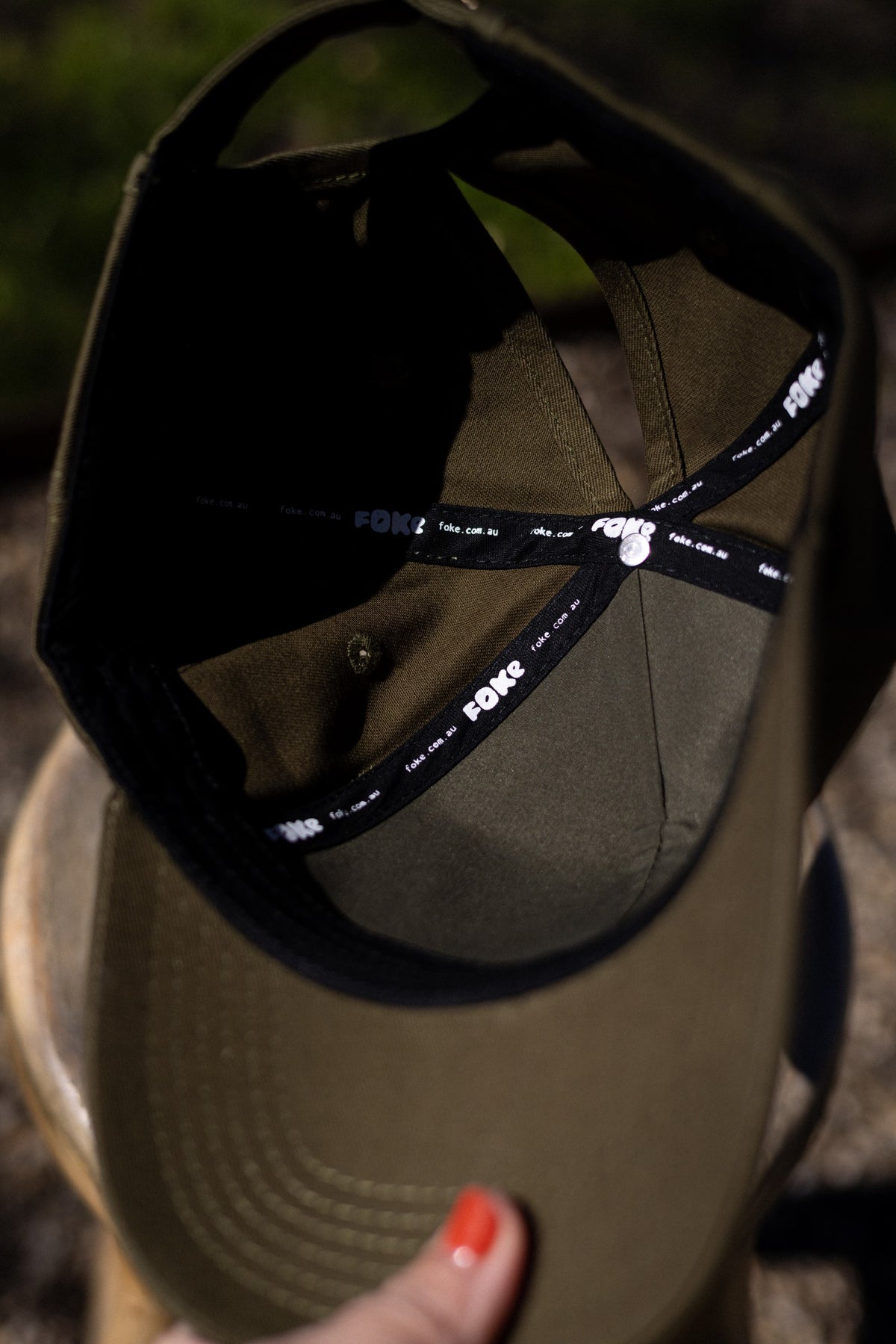 Inside the Olive cotton cap, showing black seam tape with white FOKE branding.