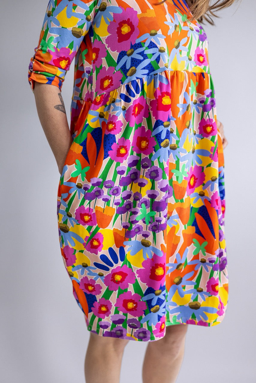 Close-up of the REN Dress in Bloomcore showing the relaxed shape, sleeve and bright floral print.