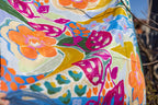 Close-up of Offbeat scarf artwork: oversized orange flowers, pink leaves and blue, green and yellow brushwork.