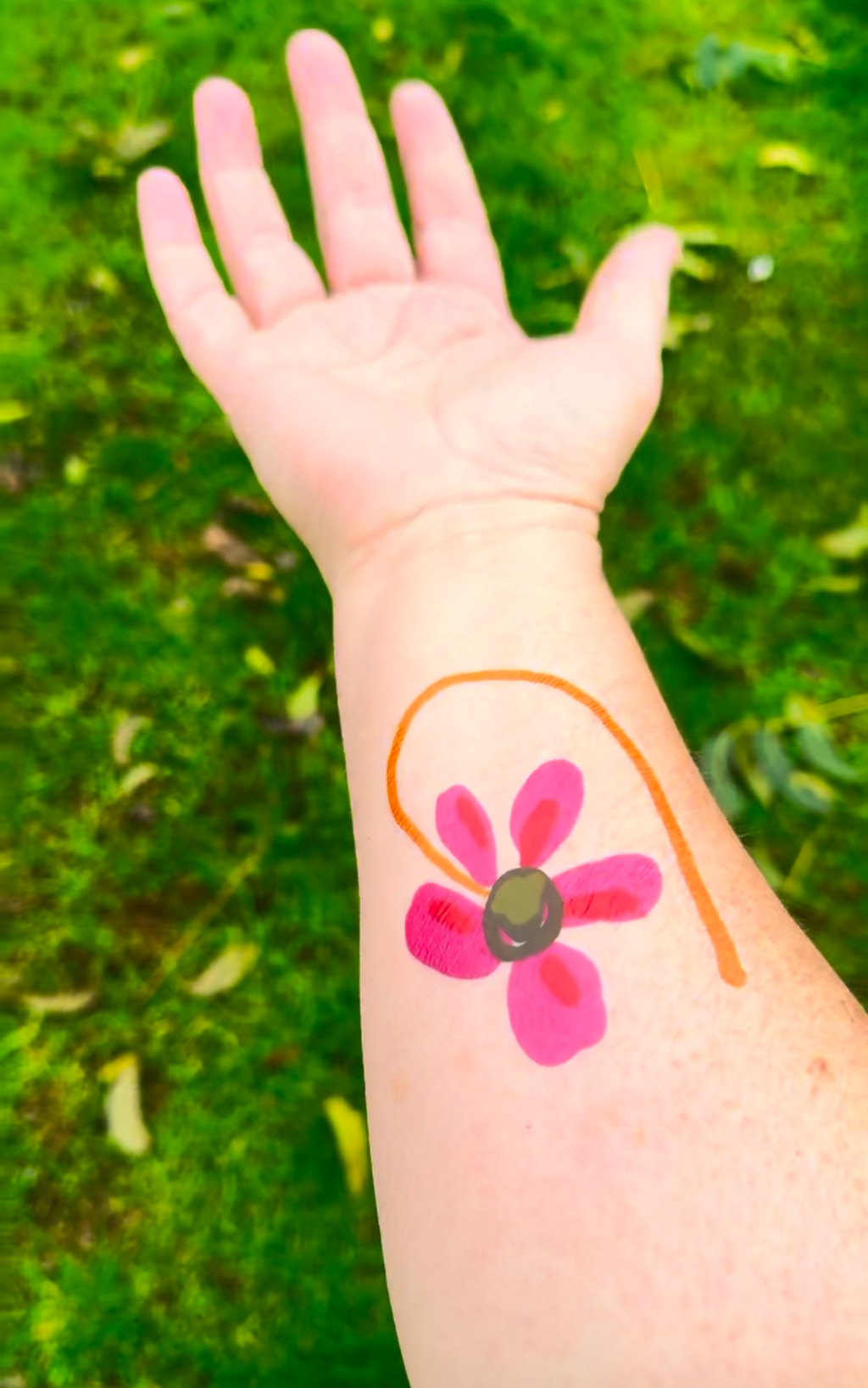 Pink FOKE flower temporary tattoo with a curved orange stem worn on a forearm.